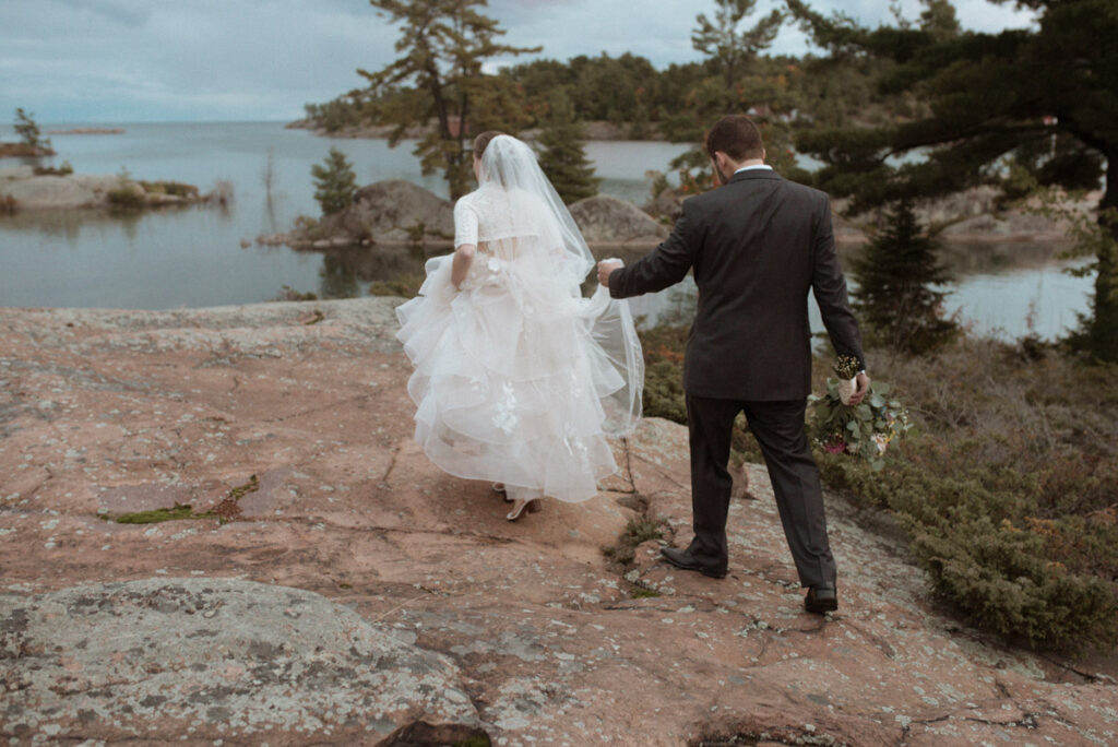 Killarney Mountain Lodge Wedding couple on a rock with Georgian Bay in the background. 