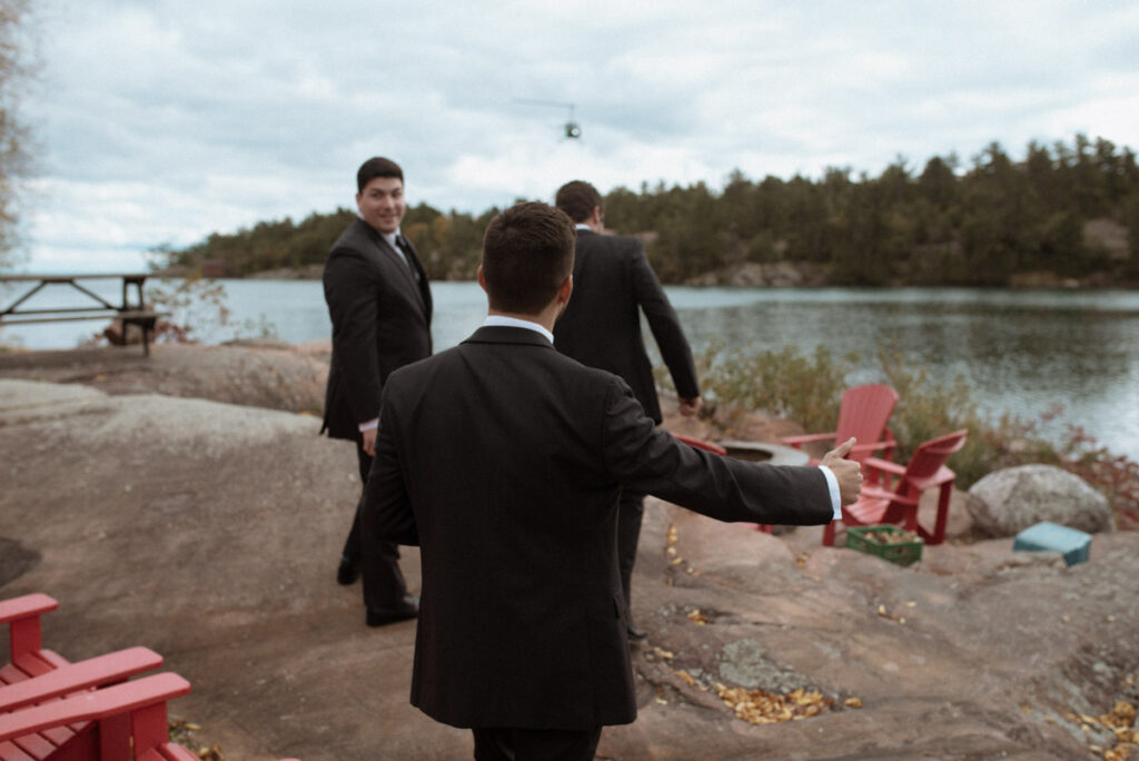 Killarney Mountain Lodge Wedding - groomsmen hitch hiking with thumb out to a helicopter. 