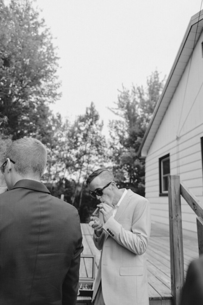 Sudbury Backyard Wedding groom lighting a cigar.