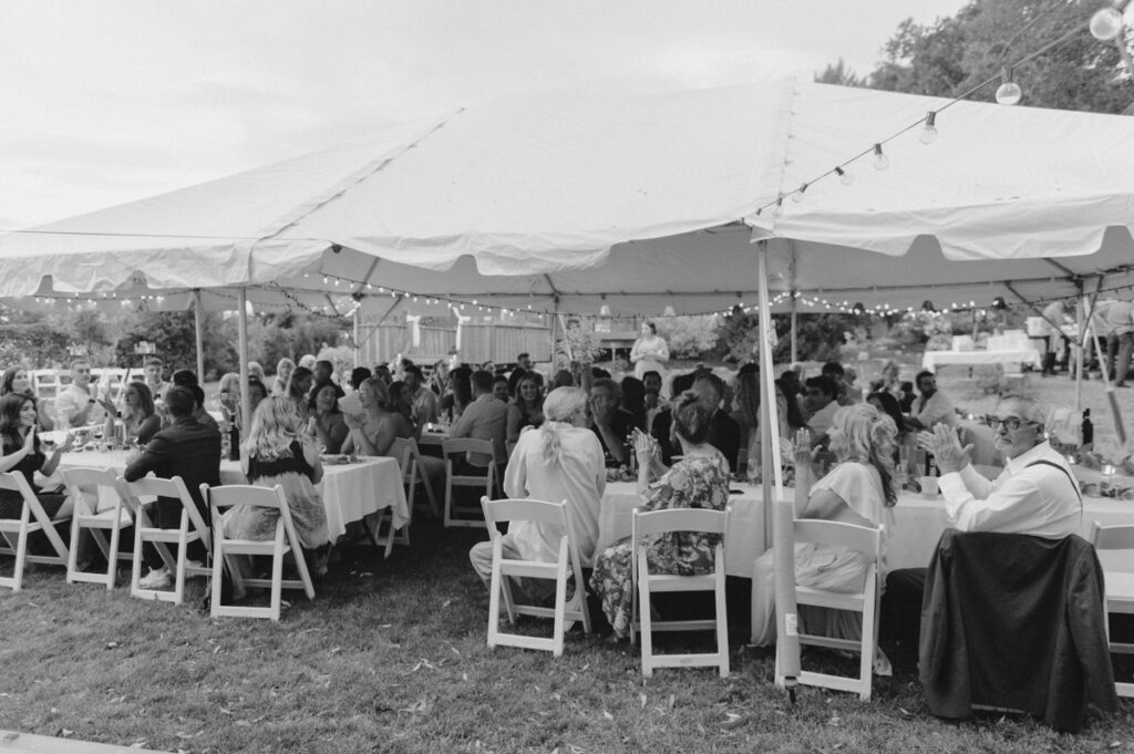 Sudbury backyard wedding reception tent with all the guest clapping. 