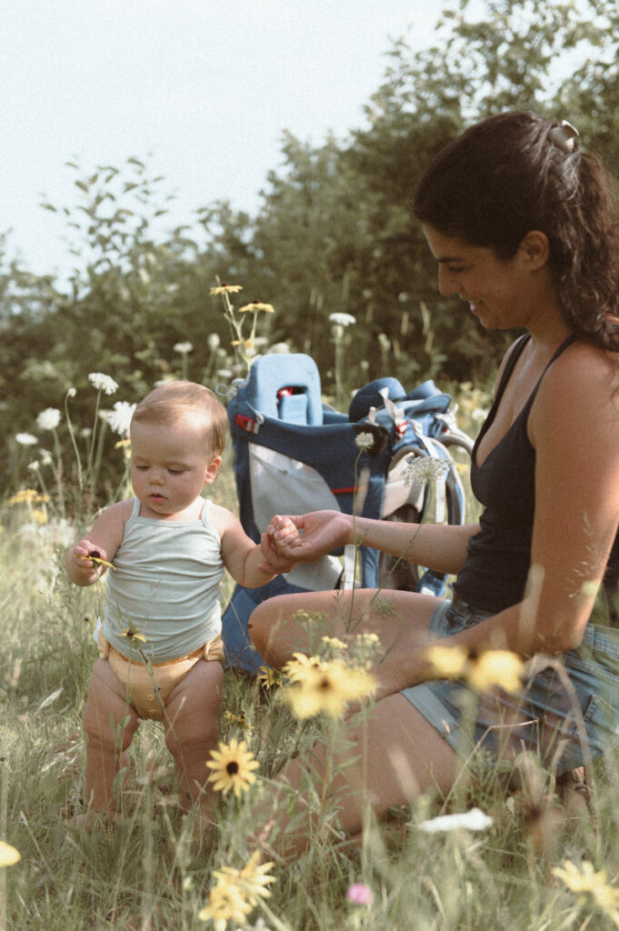 Little girl playing with flower in Sudbury field documented by a Sudbury photographer. 