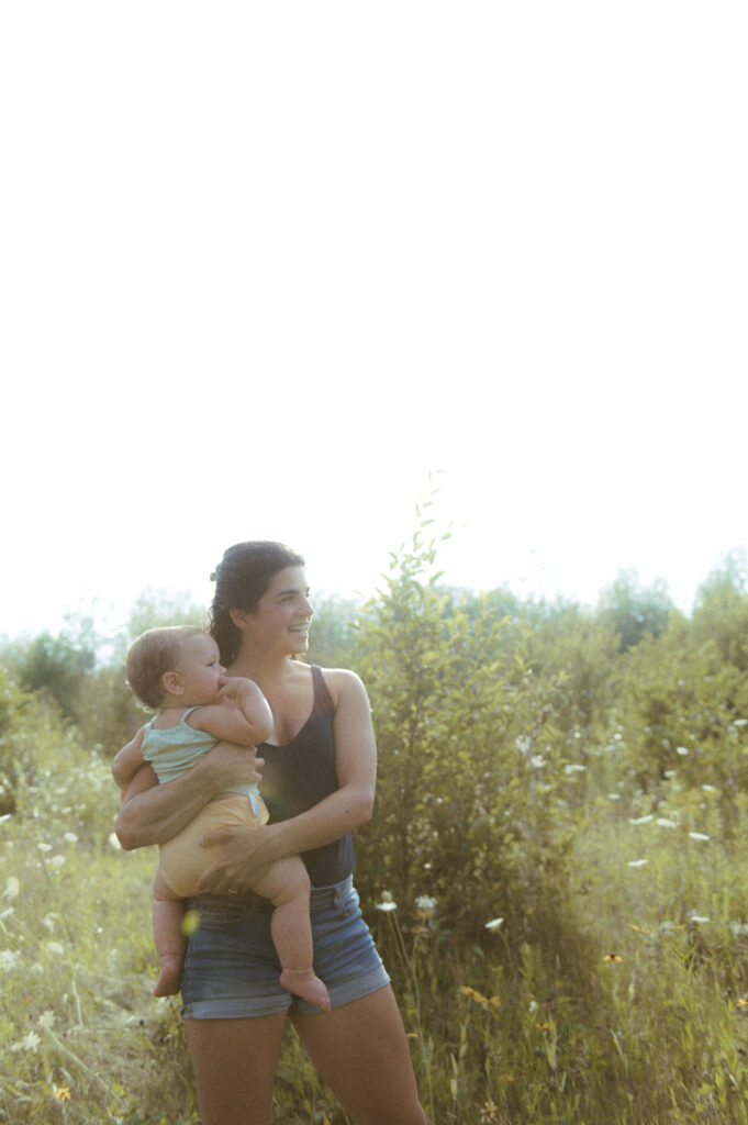 Mother holding daughter in Sudbury field documented by a Sudbury photographer. 