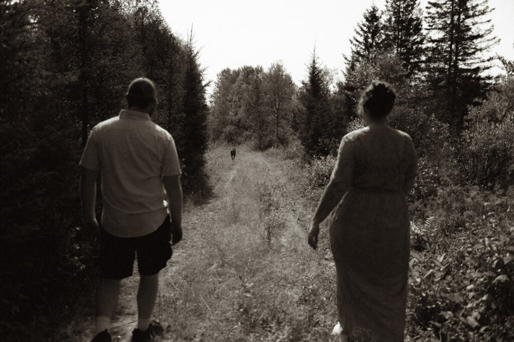 male and pregnant female couple in a field with a dog by an Ontario Documentary Photographer 