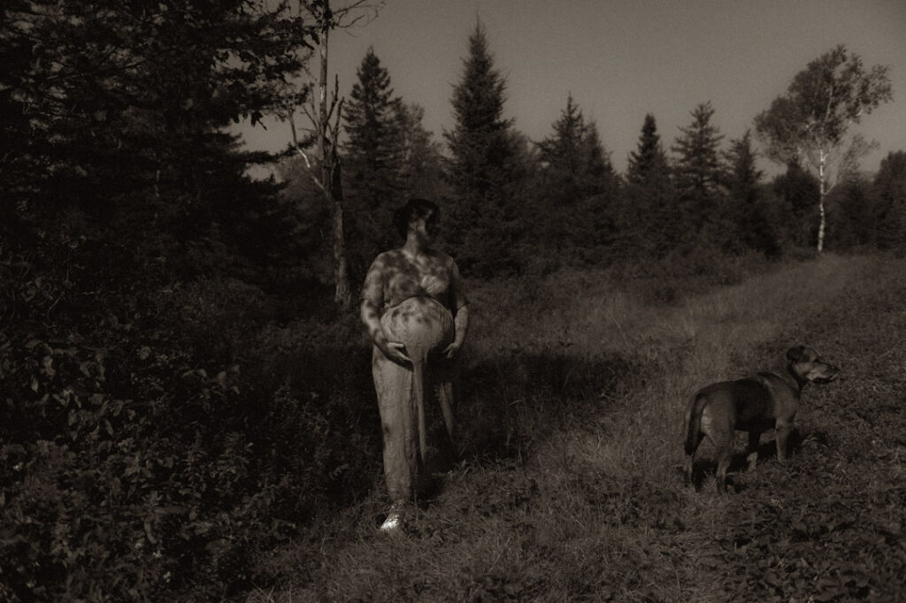 pregnant female couple in a field with a dog by an Ontario Documentary Photographer 