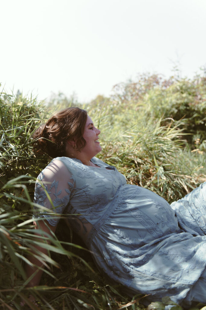 male and pregnant female couple in a field with a dog by an Ontario Documentary Photographer 