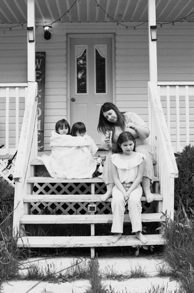 A mom and her 3 daughters on the front porch eating cereal documented by a Sudbury motherhood photographer