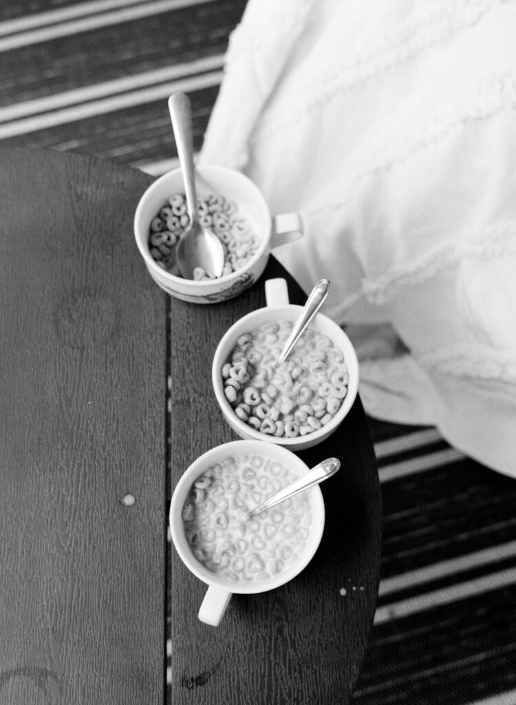 A mom and her 3 daughters on the front porch eating cereal documented by a Sudbury motherhood photographer